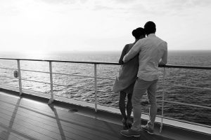 young couple hugging at sunset on cruise ship